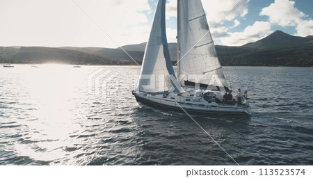 Closeup of yacht sail at ocean sun reflection aerial. Close up sailboat at ocean. Scotland seascape Closeup of yacht sail at ocean sun reflection aerial. Close up sailboat at ocean. Scotland seascape 113523574