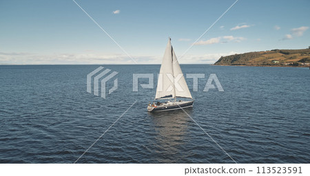 Slow motion aerial of yacht sail. Sun reflect at sea water. Nobody nature seascape. Sport recreation 113523591