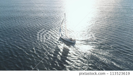 Sun shadow silhouette of yacht at ocean bay aerial. Sailing boat at sunshine reflect ocean gulf Sun shadow silhouette of yacht at ocean bay aerial. Sailing boat at sunshine reflect ocean gulf 113523619
