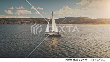 Luxury yacht race at sun light aerial. Yachting on serene seascape at open sea. Boat with white sail 113523629