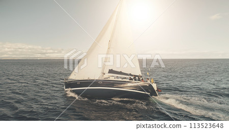 Sun shine at closeup sail boat at ocean bay aerial. Yacht race with beautiful sunny sky at open sea 113523648