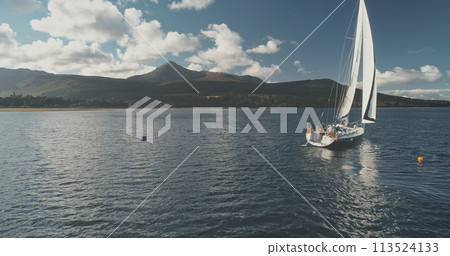 Yacht racing at ocean bay coast aerial. Passengers on sailboat at open sea at summer cloudy day 113524133