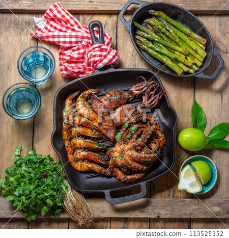 Grilled spimps, squids and octopus in cast iron grill pan Grilled spimps, squids and octopus in cast iron grill pan 113525152