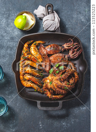 Grilled spimps, squids and octopus in cast iron grill pan Grilled spimps, squids and octopus in cast iron grill pan 113525223