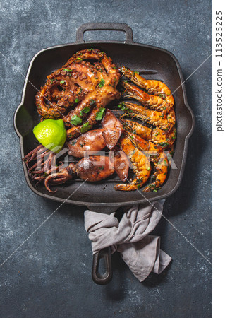 Grilled spimps, squids and octopus in cast iron grill pan Grilled spimps, squids and octopus in cast iron grill pan 113525225