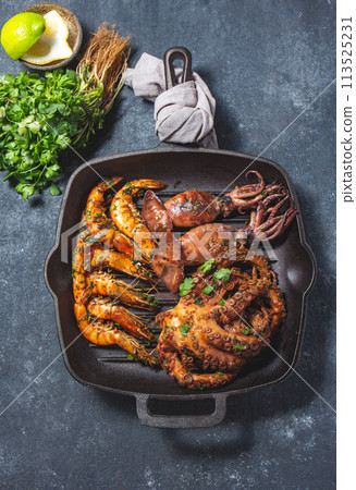 Grilled spimps, squids and octopus in cast iron grill pan Grilled spimps, squids and octopus in cast iron grill pan 113525231
