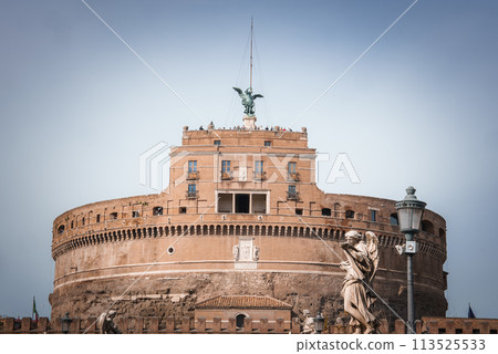 Castel Sant'Angelo, historical landmark in Rome, Italy. Fortress like structure with angel statue, old walls, statues on Ponte Sant'Angelo, visitors on terrace. Castel Sant'Angelo, historical landmark in Rome, Italy. Fortress like structure with angel statue, old walls, statues on Ponte Sant'Angelo, visitors on terrace. 113525533