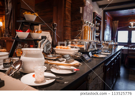 Luxury breakfast buffet in Zermatt ski resort, Switzerland. Well appointed setup with waffle maker, eggs, cereal, and more on dark countertop. Inviting alpine atmosphere. Luxury breakfast buffet in Zermatt ski resort, Switzerland. Well appointed setup with waffle maker, eggs, cereal, and more on dark countertop. Inviting alpine atmosphere. 113525776