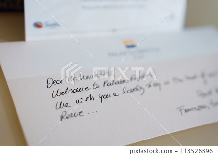 Close up handwritten welcome note to Mr. Knudsen at Palazzo Altemps, Rome, wishing a pleasant stay. Neat cursive writing with blurred hotel logo in background. Close up handwritten welcome note to Mr. Knudsen at Palazzo Altemps, Rome, wishing a pleasant stay. Neat cursive writing with blurred hotel logo in background. 113526396