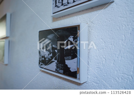 Framed black and white photo of Zermatt, Swiss ski resort, on textured white wall. Modern frame, sophisticated ambiance, suggested luxury hotel setting. 113526428