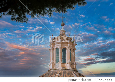 Baroque style dome with ornate lantern in European city. Ribbed design enhances aesthetic appeal under partly cloudy sky. Historical and religious architecture visible. Baroque style dome with ornate lantern in European city. Ribbed design enhances aesthetic appeal under partly cloudy sky. Historical and religious architecture visible. 113526533
