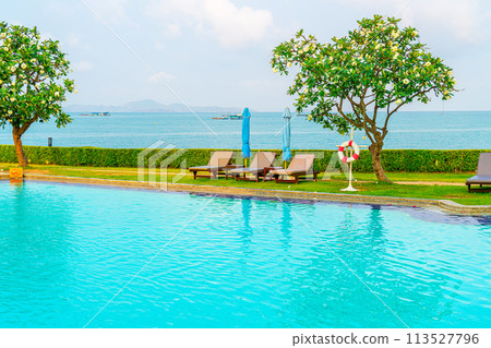 chair pool and umbrella around swimming pool 113527796