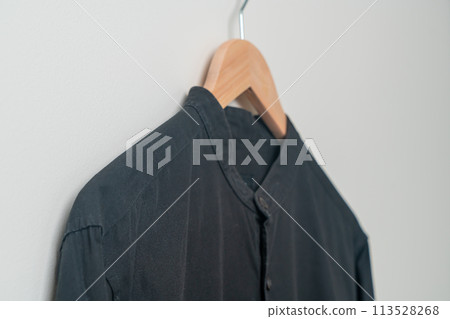 hanging shirt with wood hanger on wall 113528268
