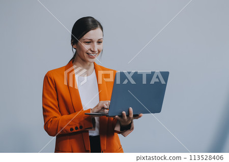 Portrait of a happy asian businesswoman working on laptop computer isolated over white background Portrait of a happy asian businesswoman working on laptop computer isolated over white background 113528406