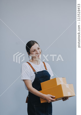 Smiling Asian woman in casual clothes holding a cardboard box mockup while standing against an isolated white background. shipping business concept 113528453
