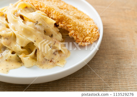 fettuccine pasta white cream sauce with fried fish 113529276