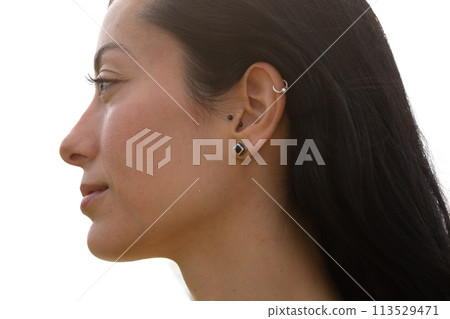 A profile portrait of a young woman showing an ear A profile portrait of a young woman showing an ear 113529471