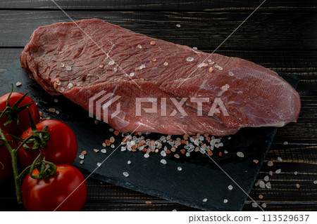 Raw beef steak with spices on a dark slate, stoneselective focus 113529637