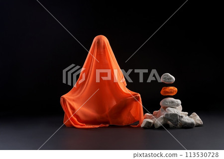 Mysterious figure of woman underneath of fabric levitate stones 113530728