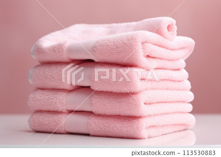 Folded pink towels on a pink background. Folded pink towels on a pink background. 113530883
