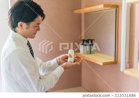A man in a suit doing skin care and facial care in the morning bathroom (lotion, cream, moisturizing, getting ready, skin care) A man in a suit doing skin care and facial care in the morning bathroom (lotion, cream, moisturizing, getting ready, skin care) 113531886
