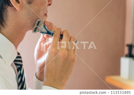 一位身穿西裝的年輕亞洲商人早上上班前在浴室刮鬍子 113531895