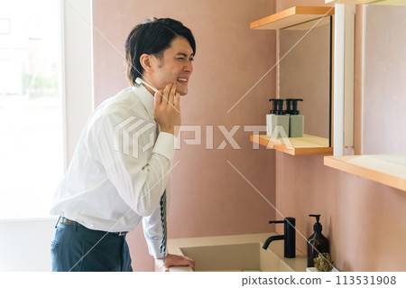 Young Asian man brushing his teeth in the bathroom (sensitivity, periodontal disease, cavities, stains) Young Asian man brushing his teeth in the bathroom (sensitivity, periodontal disease, cavities, stains) 113531908