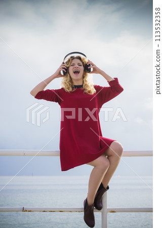 Happy woman wearing headphones outdoor Happy woman wearing headphones outdoor 113532358