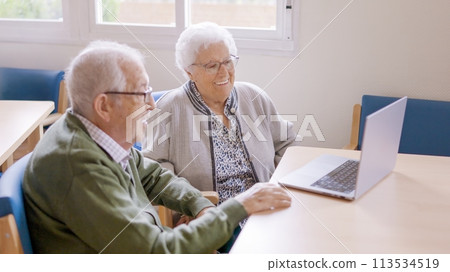 Grandparents smiling during a video call talking to their family Grandparents smiling during a video call talking to their family 113534519