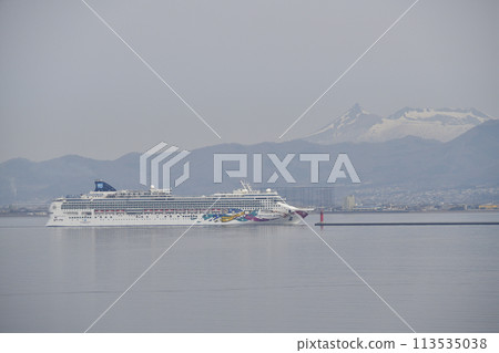 Photographing the Norwegian Jewel calling at Hakodate Port in Hakodate, Hokkaido, in the spring haze, and the snow-capped Mount Komagatake. 113535038