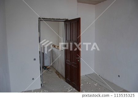Installation of an interior door in a private house.Installation of a wooden door, brown. 113535325