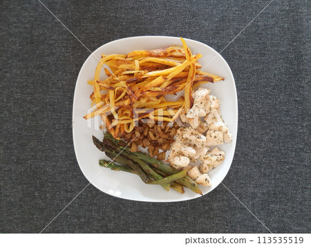 Homemade grilled chicken with french fries, eggplant and grilled asparagus, served on a white plate Homemade grilled chicken with french fries, eggplant and grilled asparagus, served on a white plate 113535519