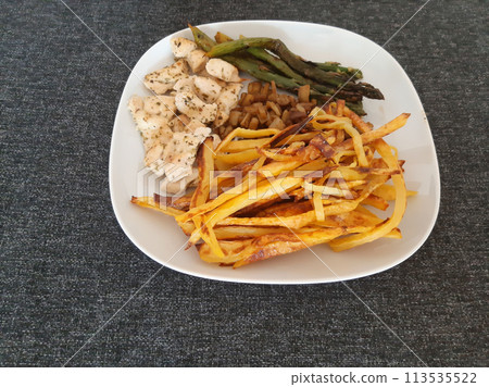 Homemade grilled chicken with french fries, eggplant and grilled asparagus, served on a white plate Homemade grilled chicken with french fries, eggplant and grilled asparagus, served on a white plate 113535522