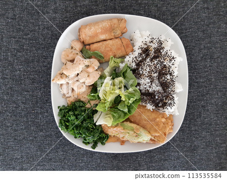 Homemade grilled chicken with grilled zucchini, green salad, spring rolls, rice pilaf and parsley. Broccoli seeds on top of the rice pilaf. Homemade grilled chicken with grilled zucchini, green salad, spring rolls, rice pilaf and parsley. Broccoli seeds on top of the rice pilaf. 113535584