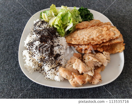 Homemade grilled chicken with grilled zucchini, green salad, spring rolls, rice pilaf and parsley. Broccoli seeds on top of the rice pilaf. 113535716