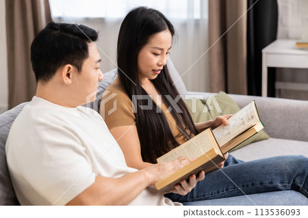 Couple Relaxing on Sofa Reading Books Together Couple Relaxing on Sofa Reading Books Together 113536093
