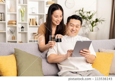 Couple Shopping Online Together On Tablet At Home Couple Shopping Online Together On Tablet At Home 113536143
