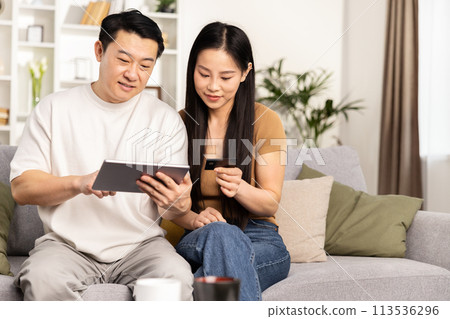 Couple Shopping Online Together on Digital Tablet 113536296