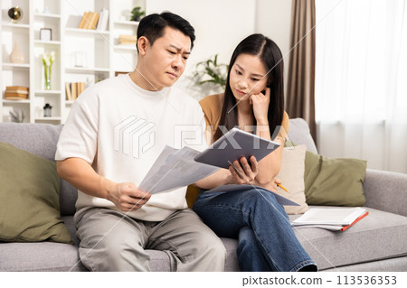Couple Managing Finances Together With Documents and Tablet 113536353