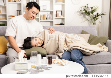 Caring Man Comforting Sick Woman at Home on Couch Caring Man Comforting Sick Woman at Home on Couch 113536354