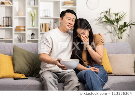 Asian Couple Enjoying Movie Night Together at Home 113536364