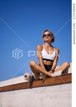 Portrait of caucasian young woman in sporty outfit relaxing meditating feeling zen-like on fitness Portrait of caucasian young woman in sporty outfit relaxing meditating feeling zen-like on fitness 113536928