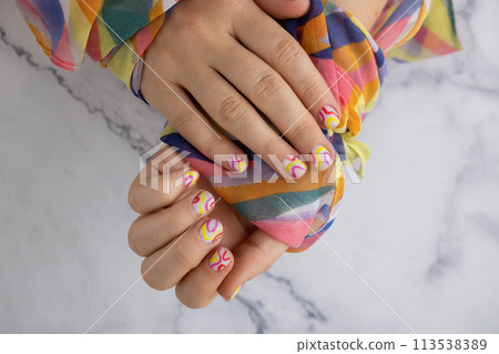 Pastel softness colorful manicured nails. Woman showing her new summer manicure in colors of pastel palette. Simplicity decor fresh spring vibes earth-colored neutral tones 113538389