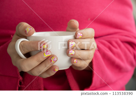 Stylish colorful summer female nails holding white cup of coffee or tea. Modern trendy stylish Beautiful manicure. Cute pastel nail minimalistic design concept of beauty treatment. Gel nails. Skin Stylish colorful summer female nails holding white cup of coffee or tea. Modern trendy stylish Beautiful manicure. Cute pastel nail minimalistic design concept of beauty treatment. Gel nails. Skin 113538390