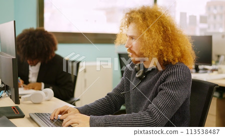 Modern concentrated man working in coworking space 113538487