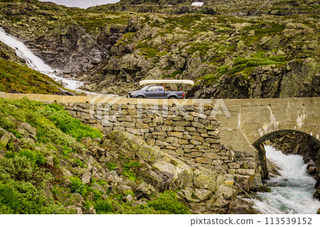 Car with canoe on top in mountains 113539152