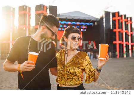 Lovely couple having fun at festival. Young friends with beer at beach party. Summer holiday, vacation. 113540142