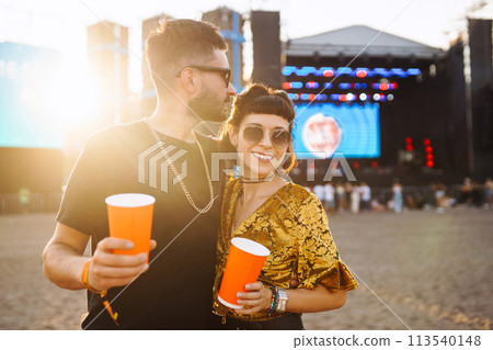 Lovely couple having fun at festival. Young friends with beer at beach party. Summer holiday, vacation. 113540148