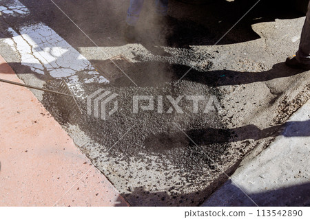 Resurfacing of bad road in city is being carried out with installation of new asphalt construction 113542890