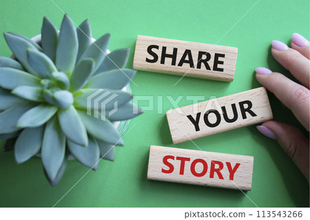 Share your story symbol. Wooden blocks with words Share your story. Beautiful green background. Businessman hand. Business and Share your story concept. Copy space. 113543266